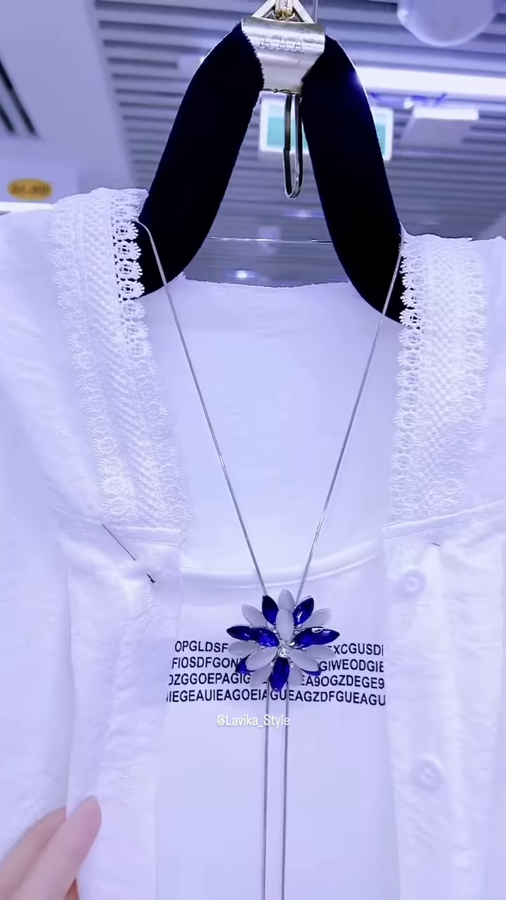 Elegant White Layered Outfit with Striking Blue Necklace - Image 4